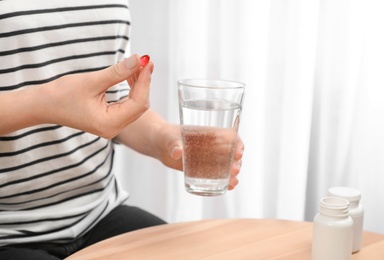 Young woman taking pill, closeup