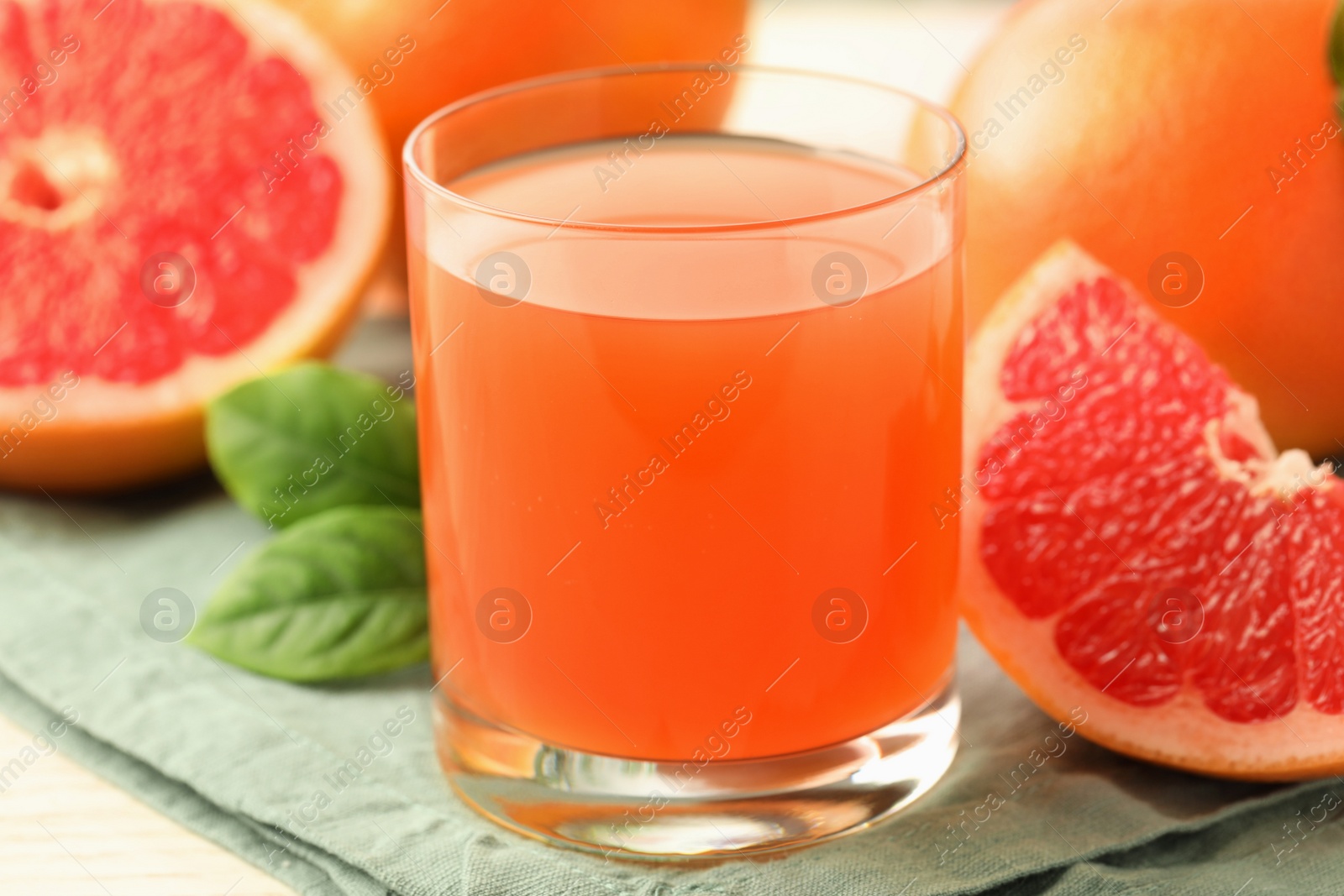 Photo of Glass of delicious grapefruit juice on table, closeup