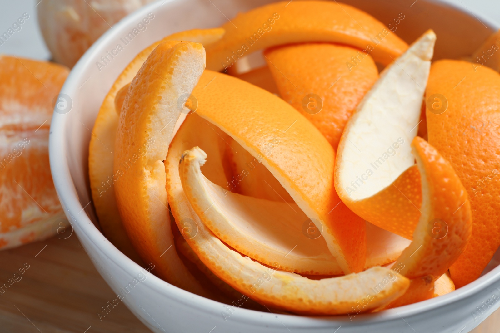 Photo of Orange zest preparing for drying and fresh fruits on wooden table, closeup