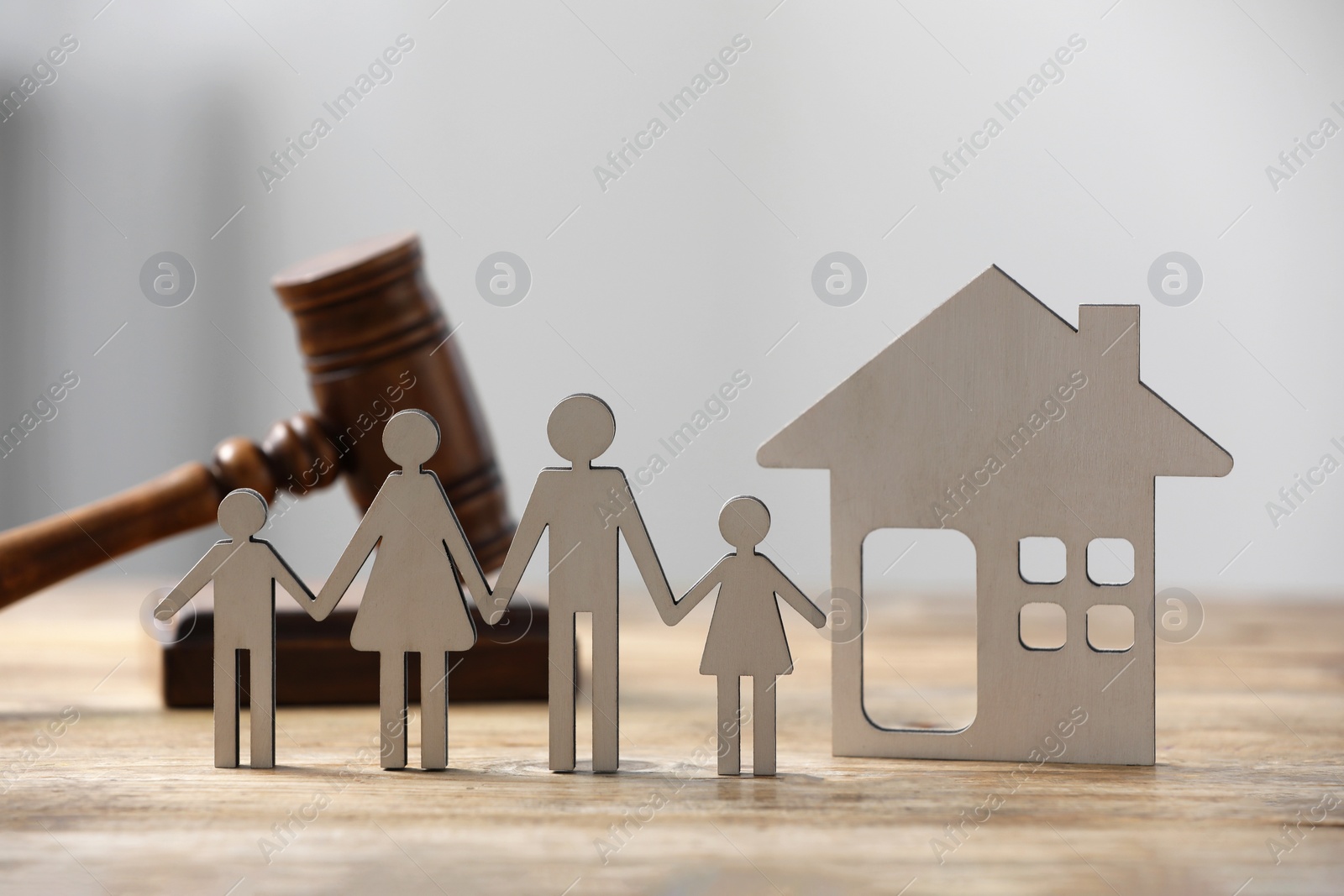 Photo of Family law. Figure of parents with children, house model and gavel on wooden table