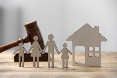 Family law. Figure of parents with children, house model and gavel on wooden table