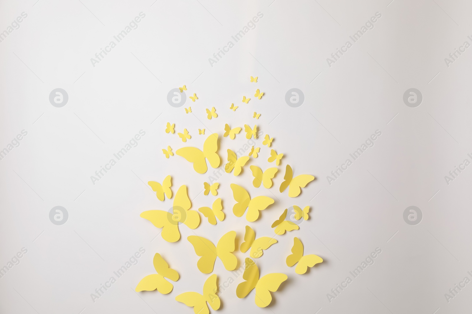 Photo of Yellow paper butterflies on white background, top view