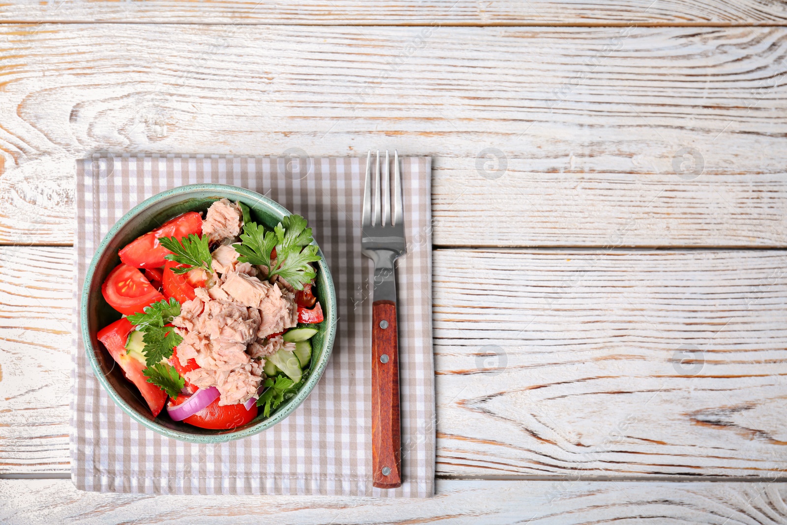 Photo of Delicious salad with canned tuna in bowl on wooden background, top view