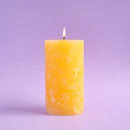 Alight scented wax candle on color background