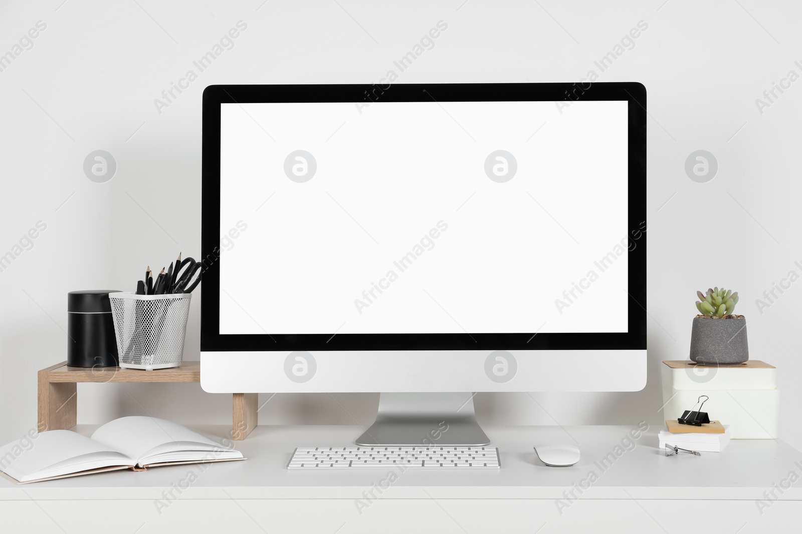 Photo of Cozy workspace with computer, houseplant and stationery on white desk at home