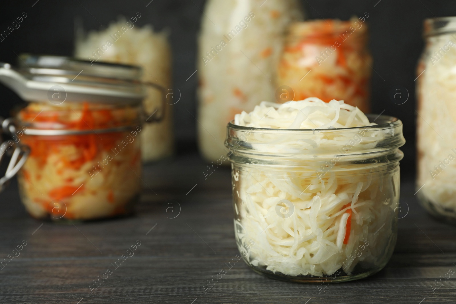 Photo of Tasty fermented cabbage on black wooden table