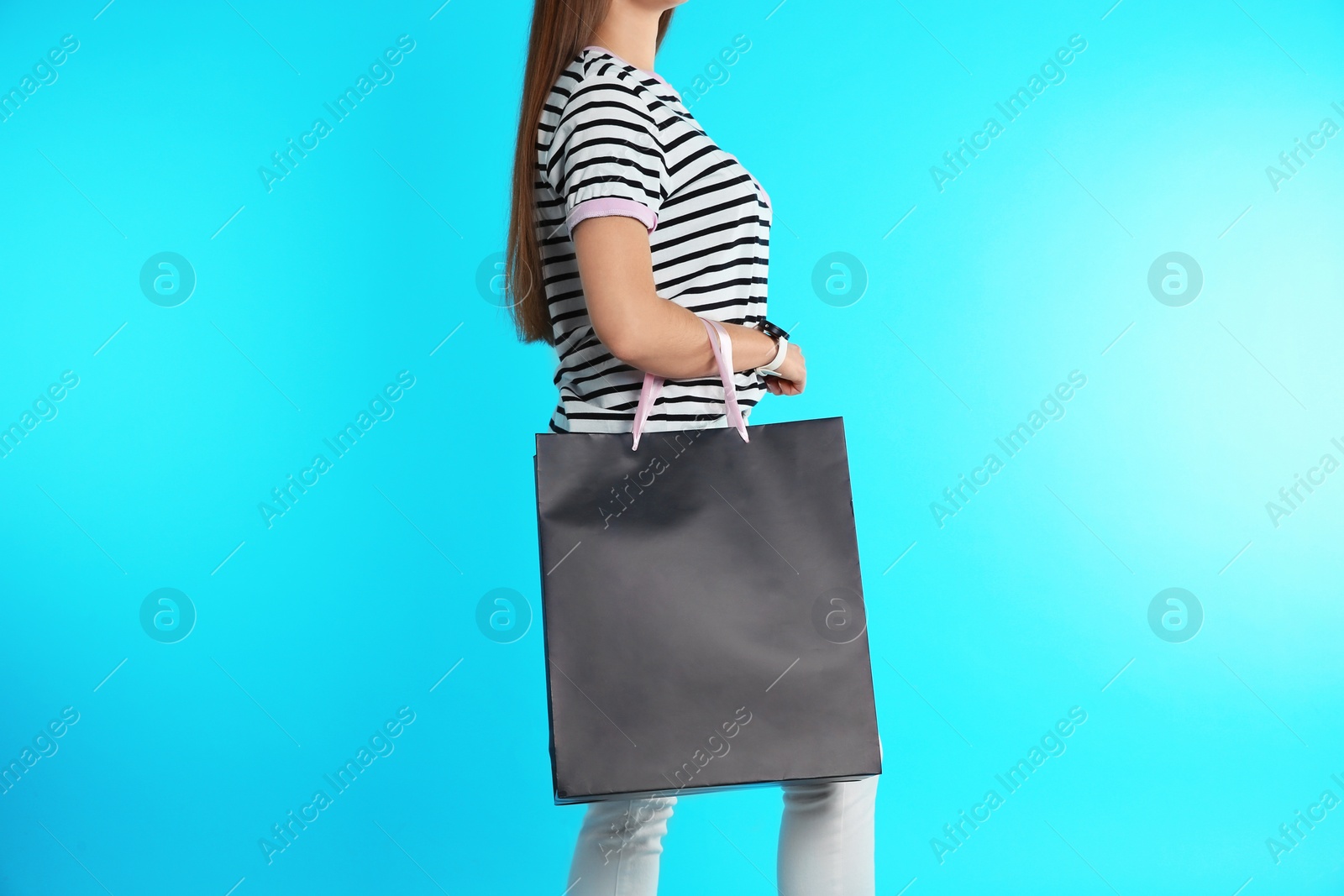 Photo of Woman with paper shopping bag on color background. Mock up for design