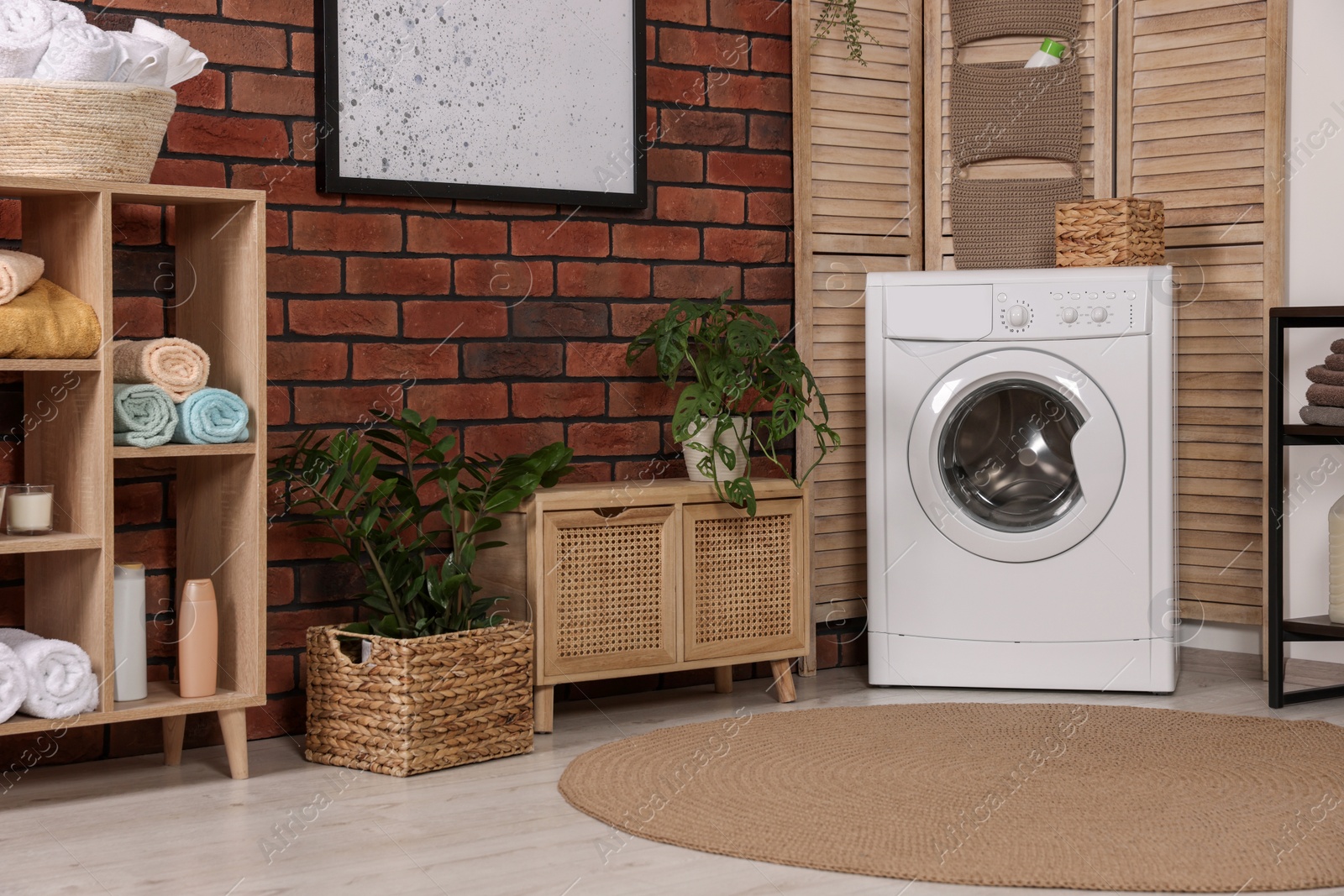 Photo of Stylish laundry room with washing machine. Interior design