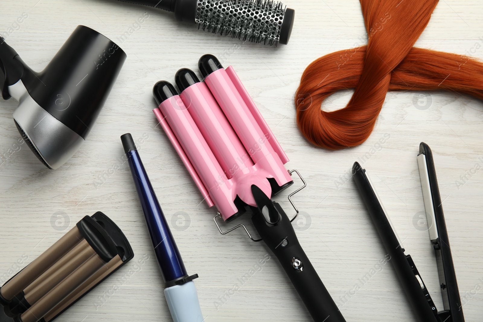 Photo of Flat lay composition with hairdressing equipment on white wooden background