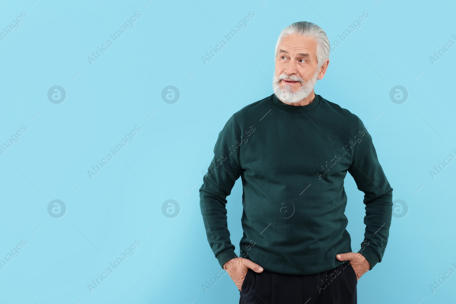 Photo of Portrait of handsome senior man on light blue background. Space for text