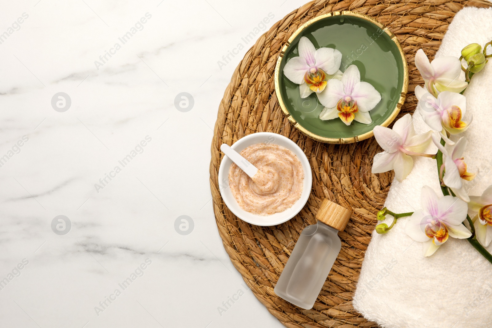 Photo of Composition with different spa products and flowers on white marble table, top view. Space for text