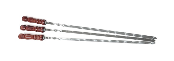 Photo of Metal skewers with wooden handle on white background, top view