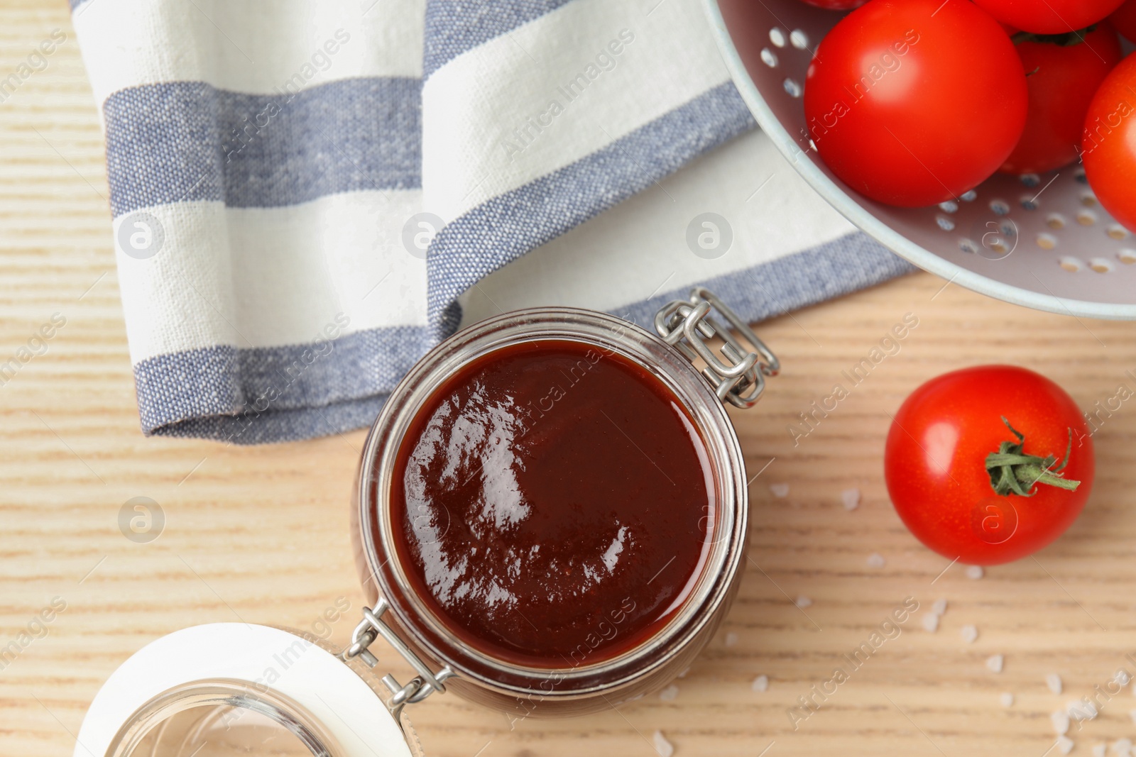 Photo of Flat lay composition with barbecue sauce and tomatoes on wooden table