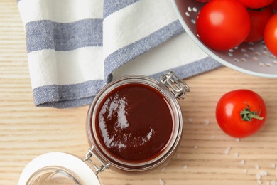 Photo of Flat lay composition with barbecue sauce and tomatoes on wooden table