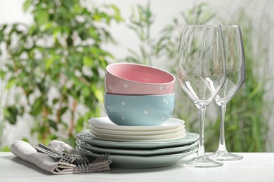 Photo of Beautiful ceramic dishware, glasses and cutlery on white table outdoors