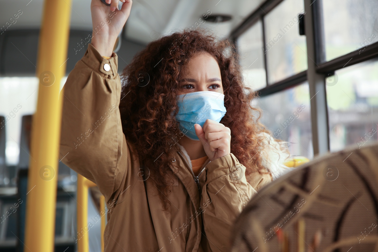 Photo of African-American woman with disposable mask on bus. Virus protection
