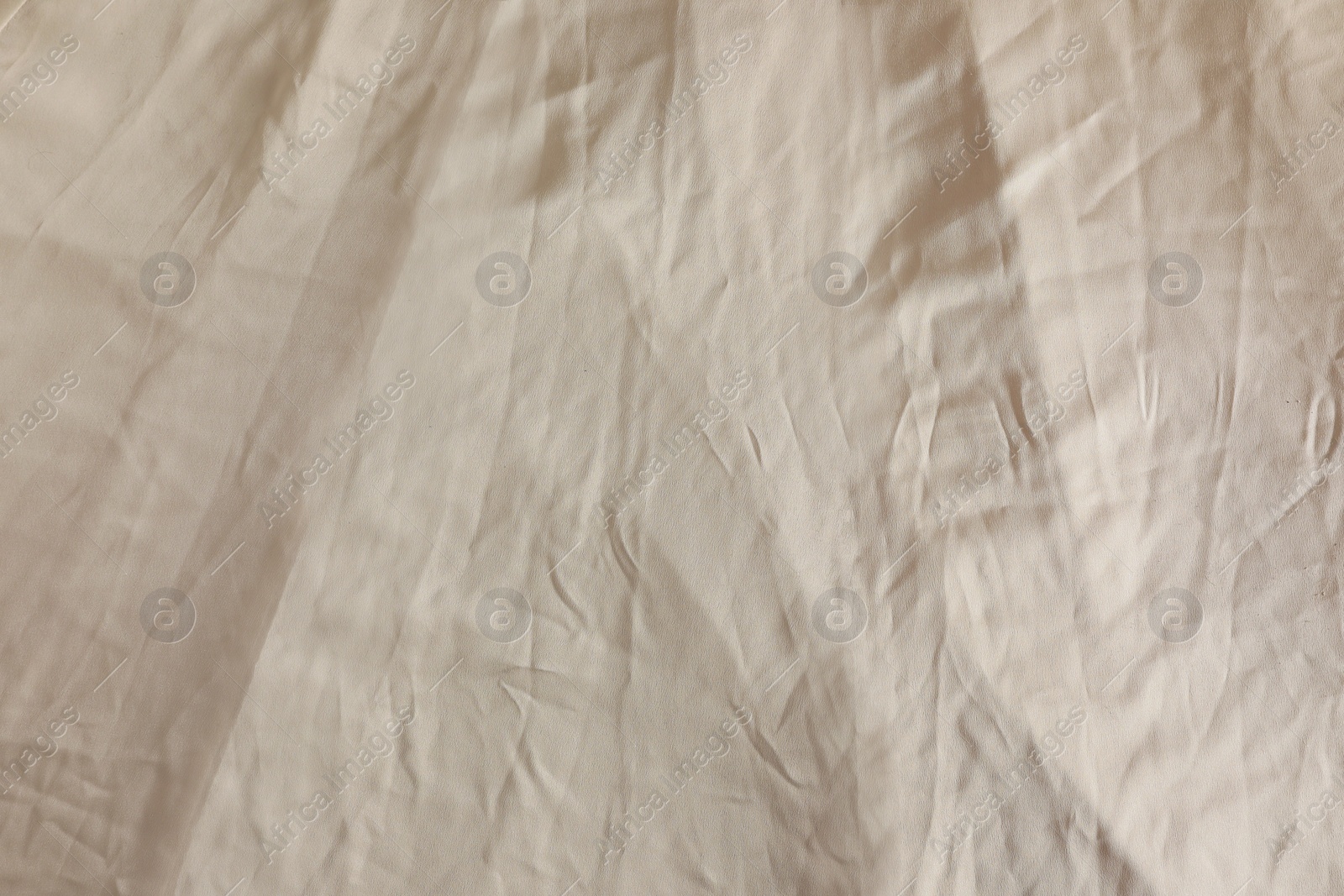 Photo of Crumpled dark beige fabric as background, closeup view