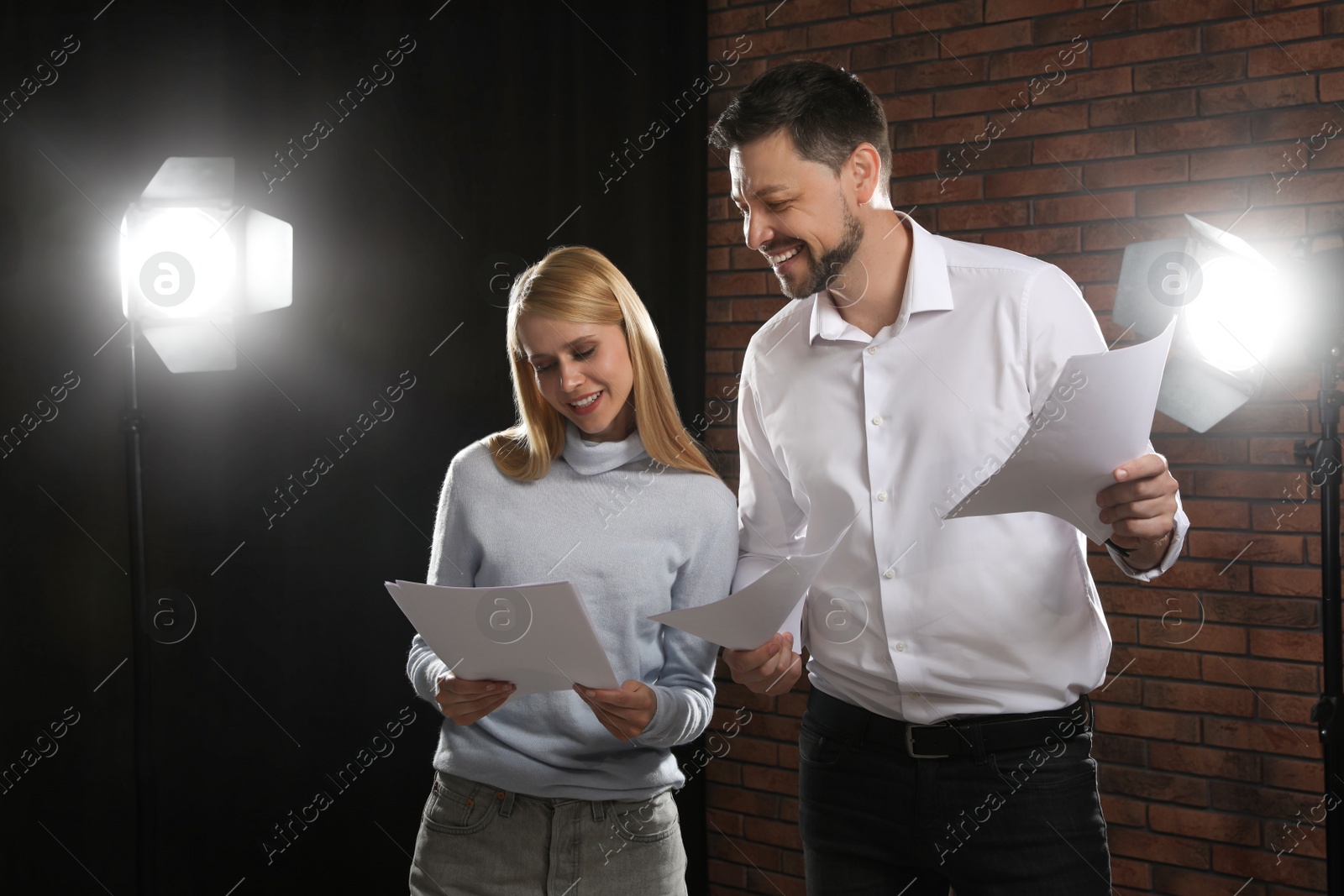 Photo of Professional actors reading their scripts during rehearsal in theatre