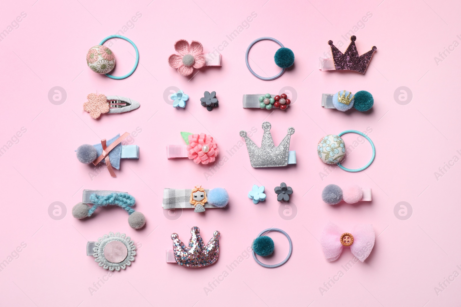 Photo of Beautiful hair clips and bands on pink background, flat lay