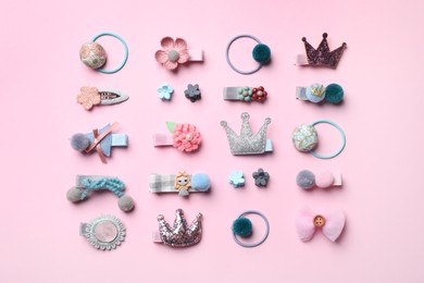 Beautiful hair clips and bands on pink background, flat lay