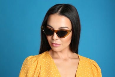 Photo of Beautiful woman wearing sunglasses on blue background