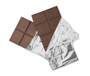 Photo of Delicious dark chocolate bars wrapped in foil isolated on white, top view