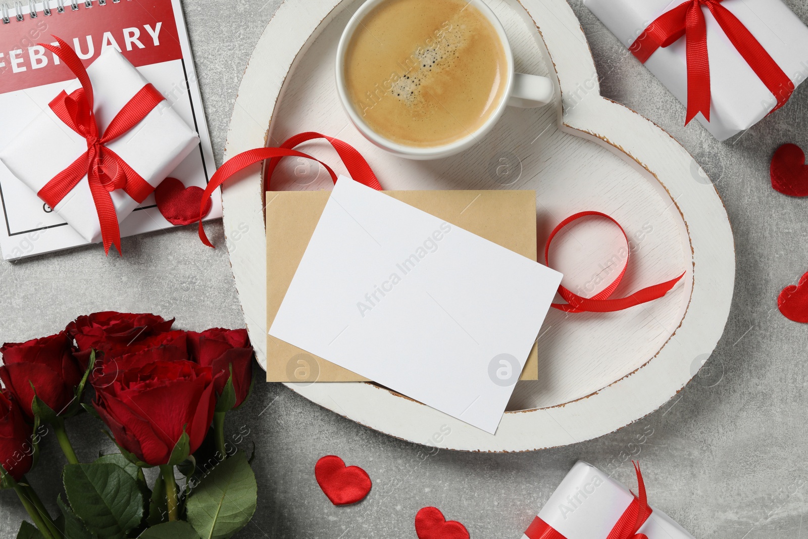 Photo of Flat lay composition with blank greeting card, gifts and coffee on light grey stone table. Valentine's day celebration