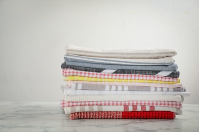 Photo of Stacked kitchen towels on white marble table