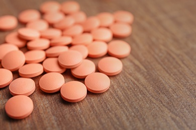 Photo of Orange pills on wooden background