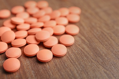 Orange pills on wooden background