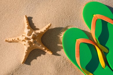 Stylish flip flops and starfish on beach, flat lay