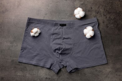 Man's underwear and cotton flowers on grey table, flat lay