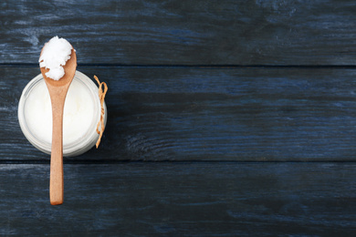 Photo of Coconut oil on dark wooden table, top view with space for text. Cooking ingredient