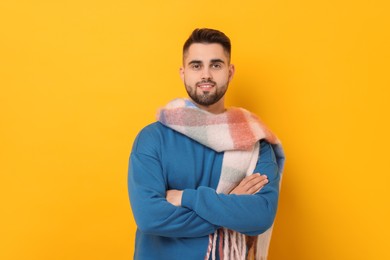 Photo of Smiling man in warm scarf on yellow background