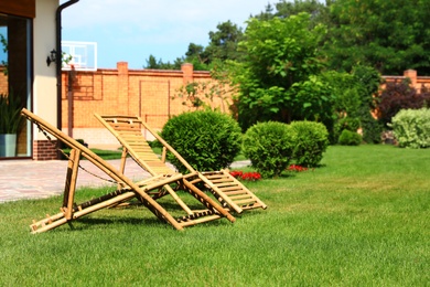 Photo of Wooden deck chairs in garden on sunny day