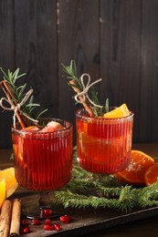 Christmas Sangria cocktail in glasses, ingredients and fir tree branches on wooden table