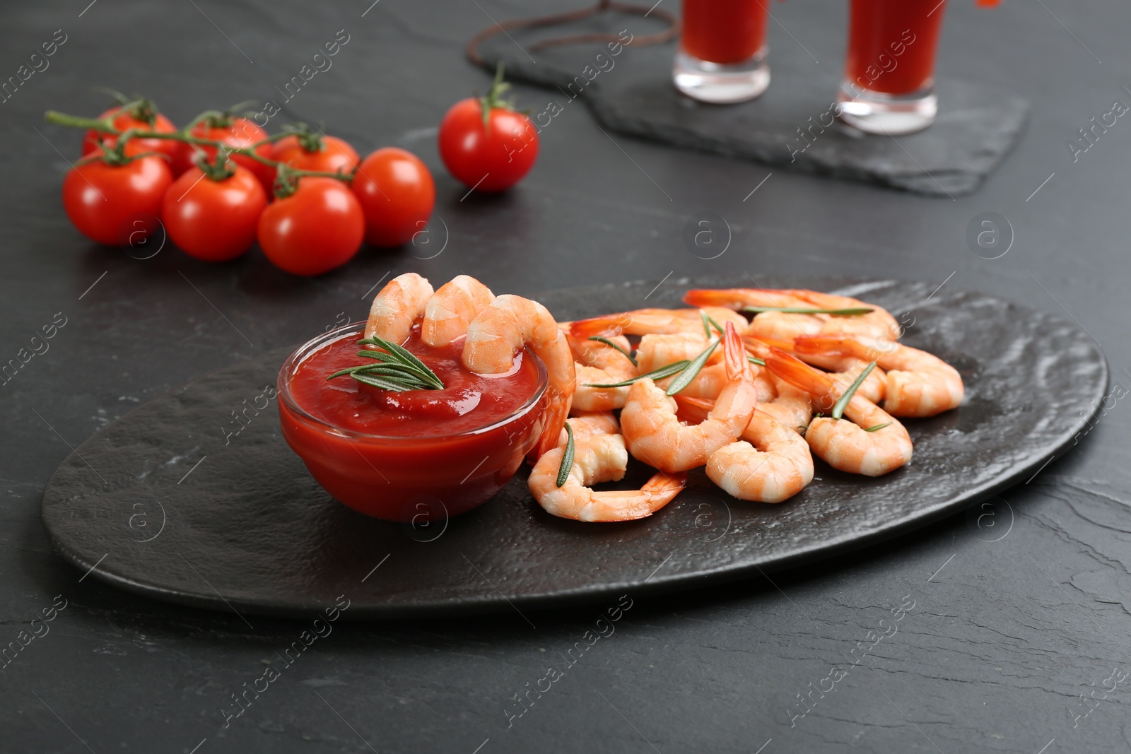 Photo of Delicious shrimp cocktail with tomato sauce served on black table