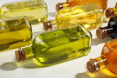 Vegetable fats. Different cooking oils in glass bottles on white background, closeup