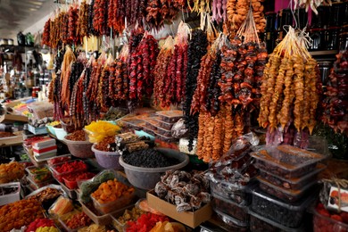 Photo of Bunches of different delicious churchkhelas and dried fruits at market