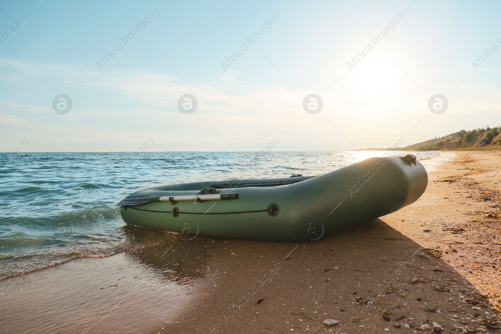 Photo of Inflatable rubber fishing boat on sandy beach near sea