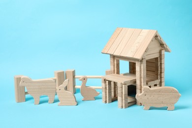 Photo of Wooden house and animals on light blue background. Children's toy