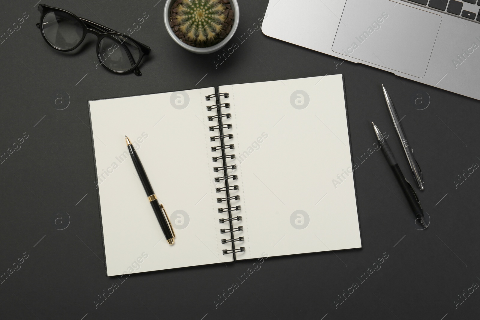 Photo of Flat lay composition with notebook and laptop on black table