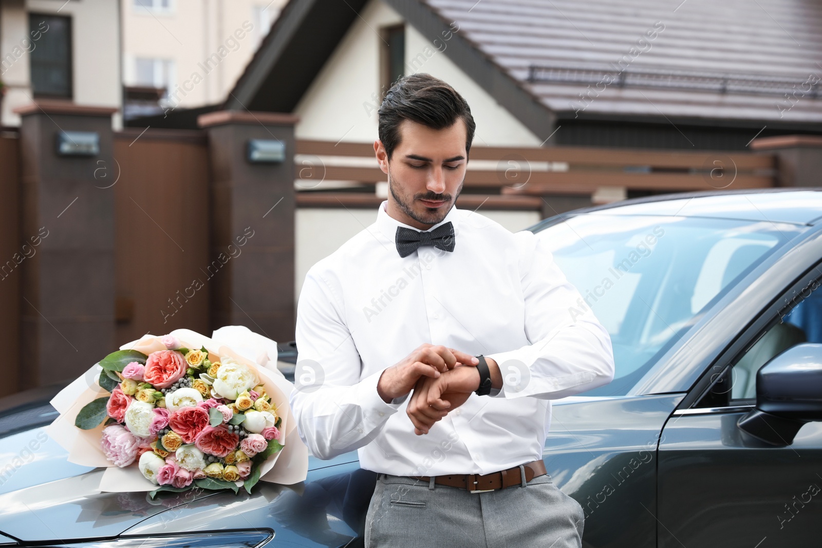 Photo of Young handsome man with beautiful flower bouquet near car outdoors