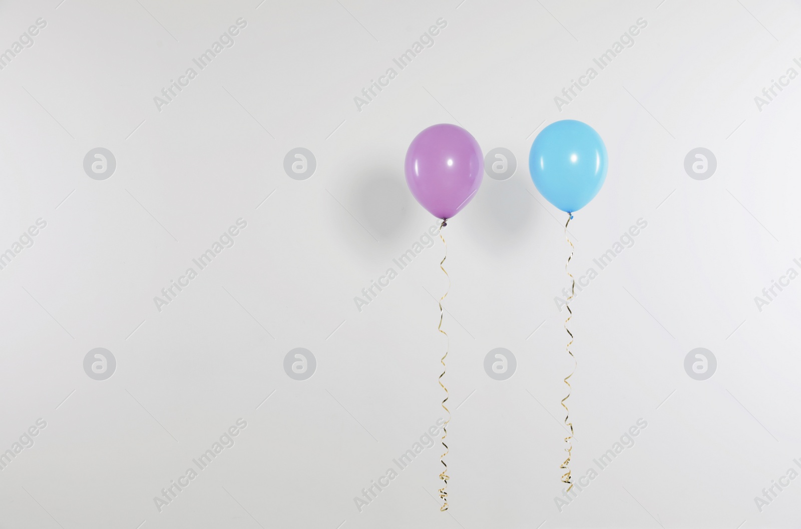 Photo of Different bright balloons on light background, space for text. Celebration time