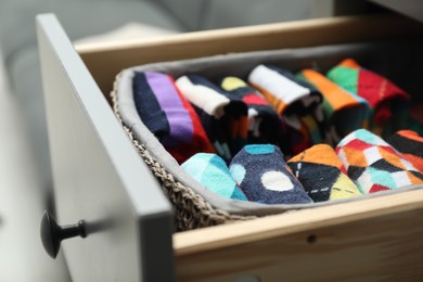 Photo of Chest of drawers with different socks, closeup