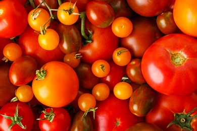 Photo of Many fresh ripe red and yellow tomatoes as background, top view
