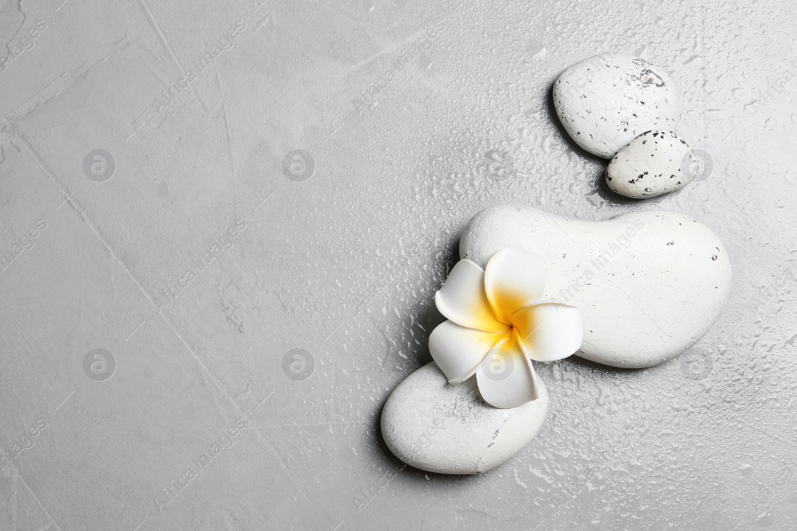 Photo of Flat lay composition with spa stones and space for text on grey background