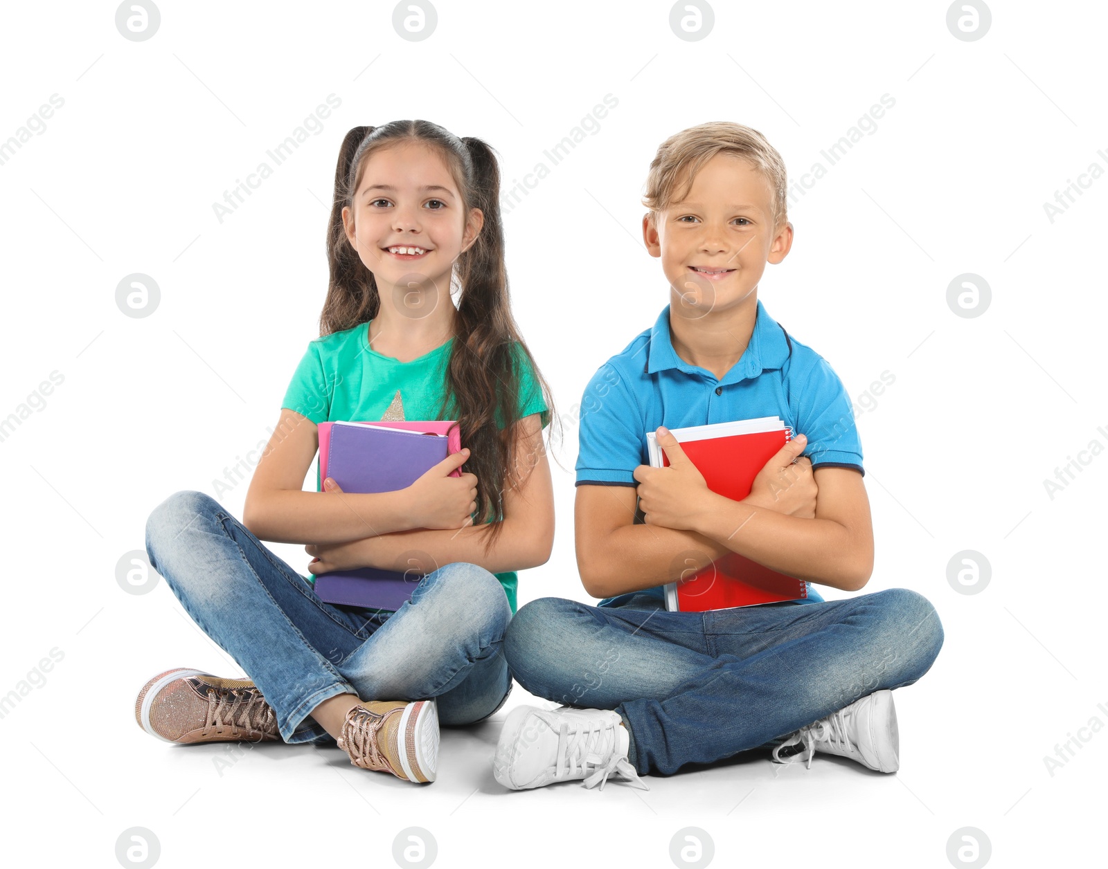 Photo of Little children with school supplies on white background