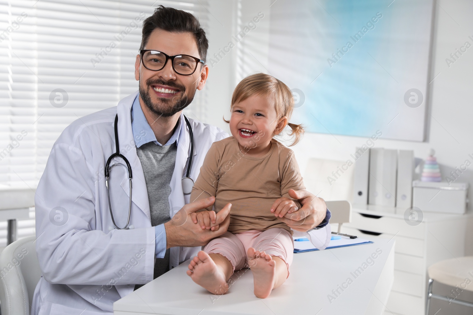 Photo of Pediatrician examining cute little baby in clinic