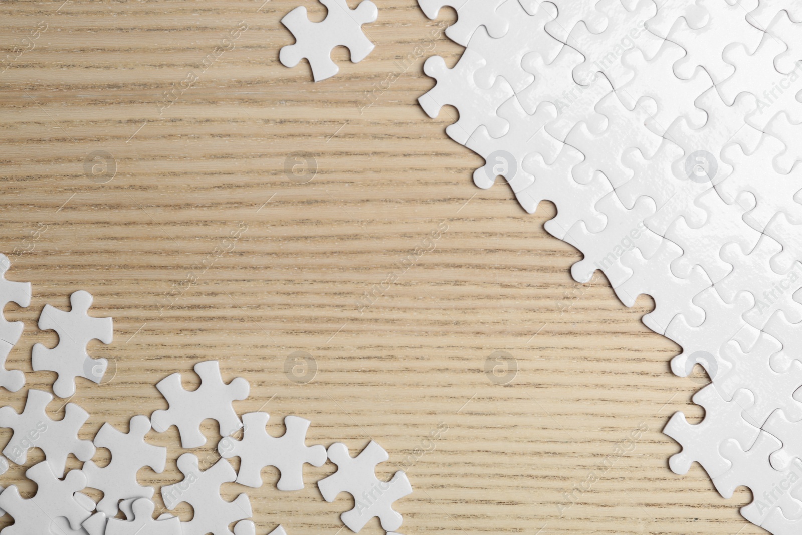 Photo of Blank white puzzle pieces on wooden background, flat lay. Space for text